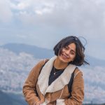 young excited female hiking in mountains and enjoying the beautiful view